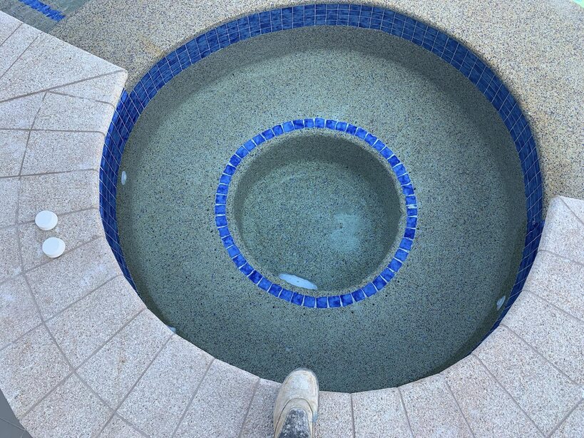 Round spa ringed with blue mosaic tiles, seen from above